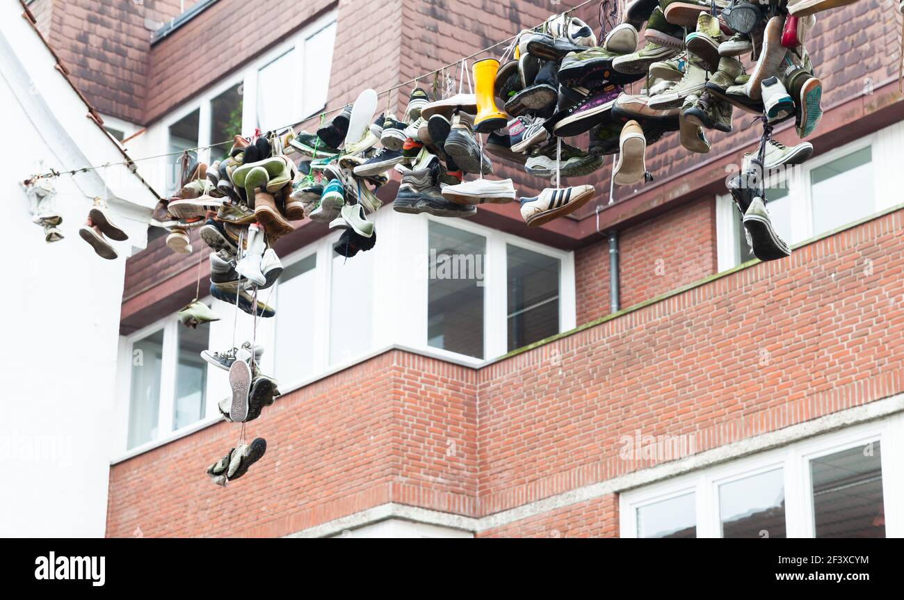 Flensburg, Allemagne - 10 février 2017 : beaucoup de chaussures abandonnées pendent sur un fil de fer au-dessus de la rue Banque D'Images