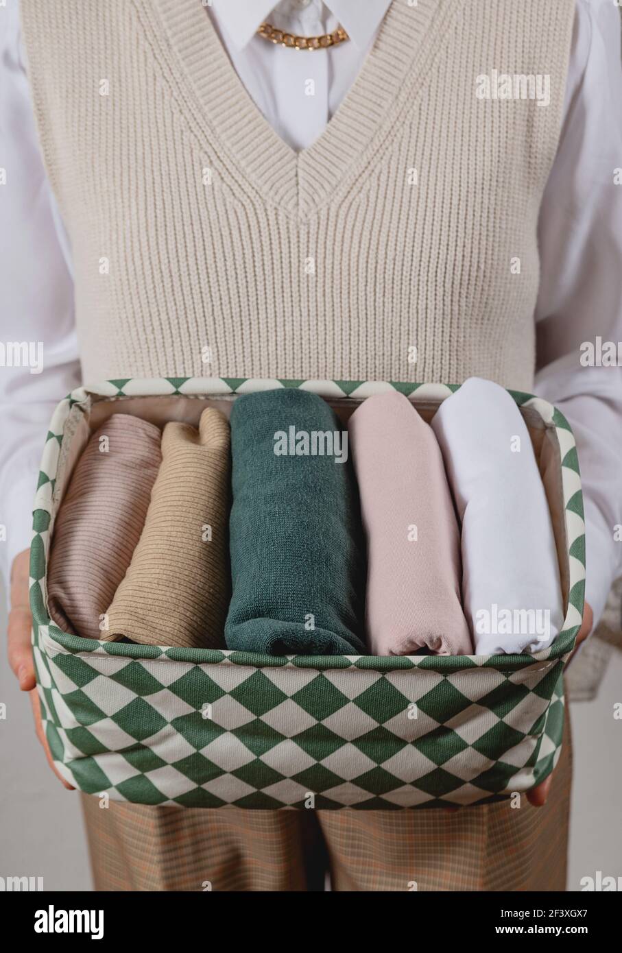 Rangement vertical des vêtements dans un récipient. Dans les mains d'une femme Banque D'Images