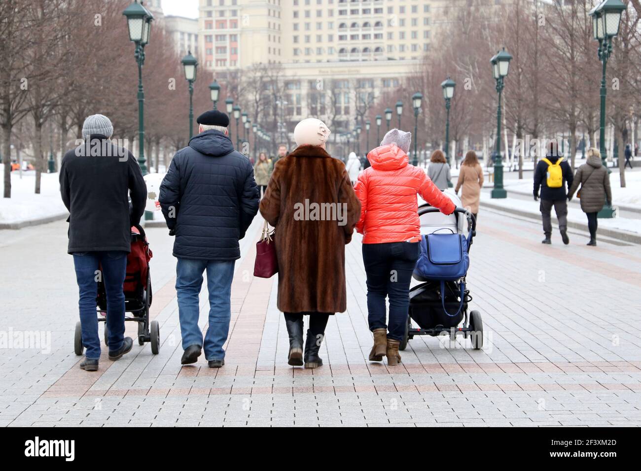 Famille avec landaus marchant dans une rue de ville de printemps À Moscou sur fond de foule de gens Banque D'Images