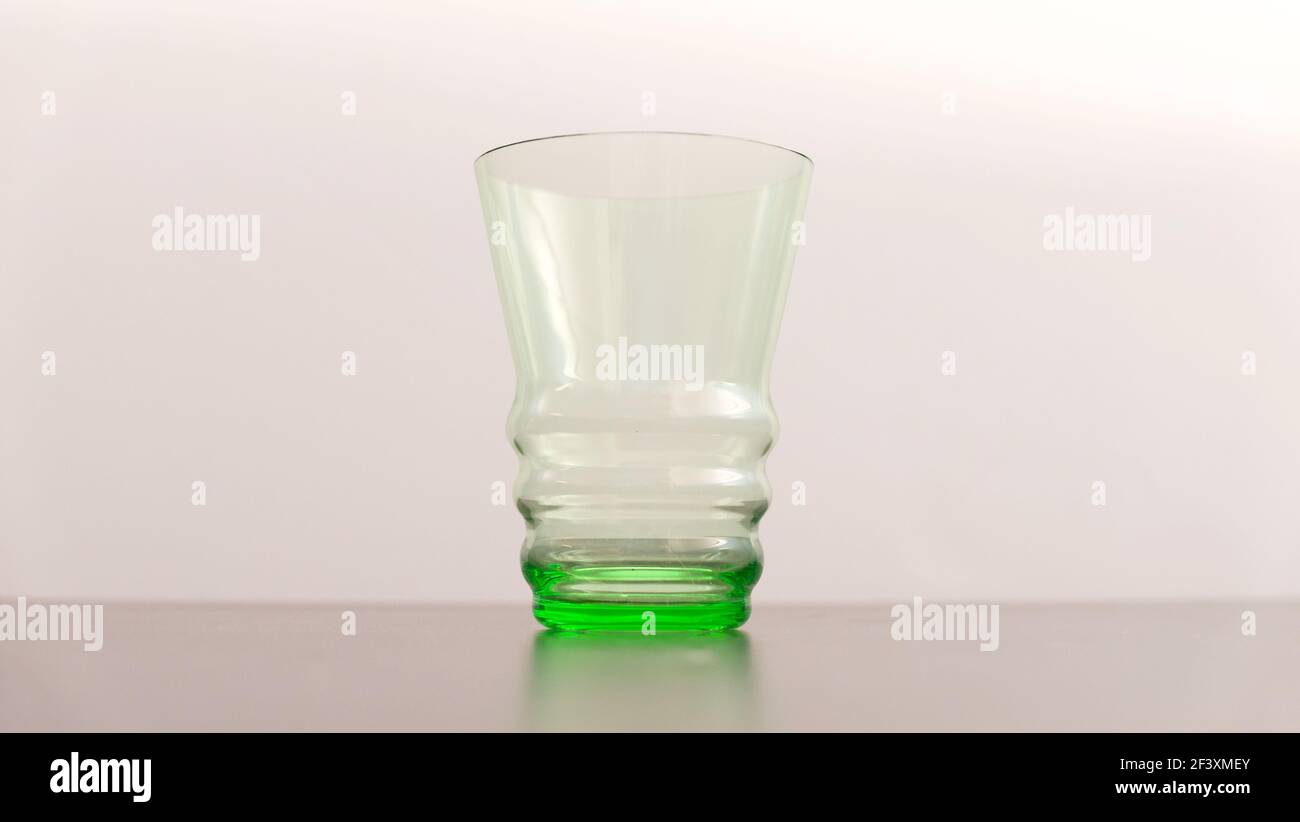 Gobelet en verre vert de style art déco contre un pâle doux arrière-plan Banque D'Images