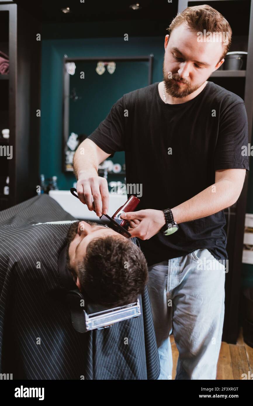 Barber effectue la tonte de la barbe pour homme client, traitement de  beauté professionnel pour hommes dans salon de coiffure Photo Stock - Alamy