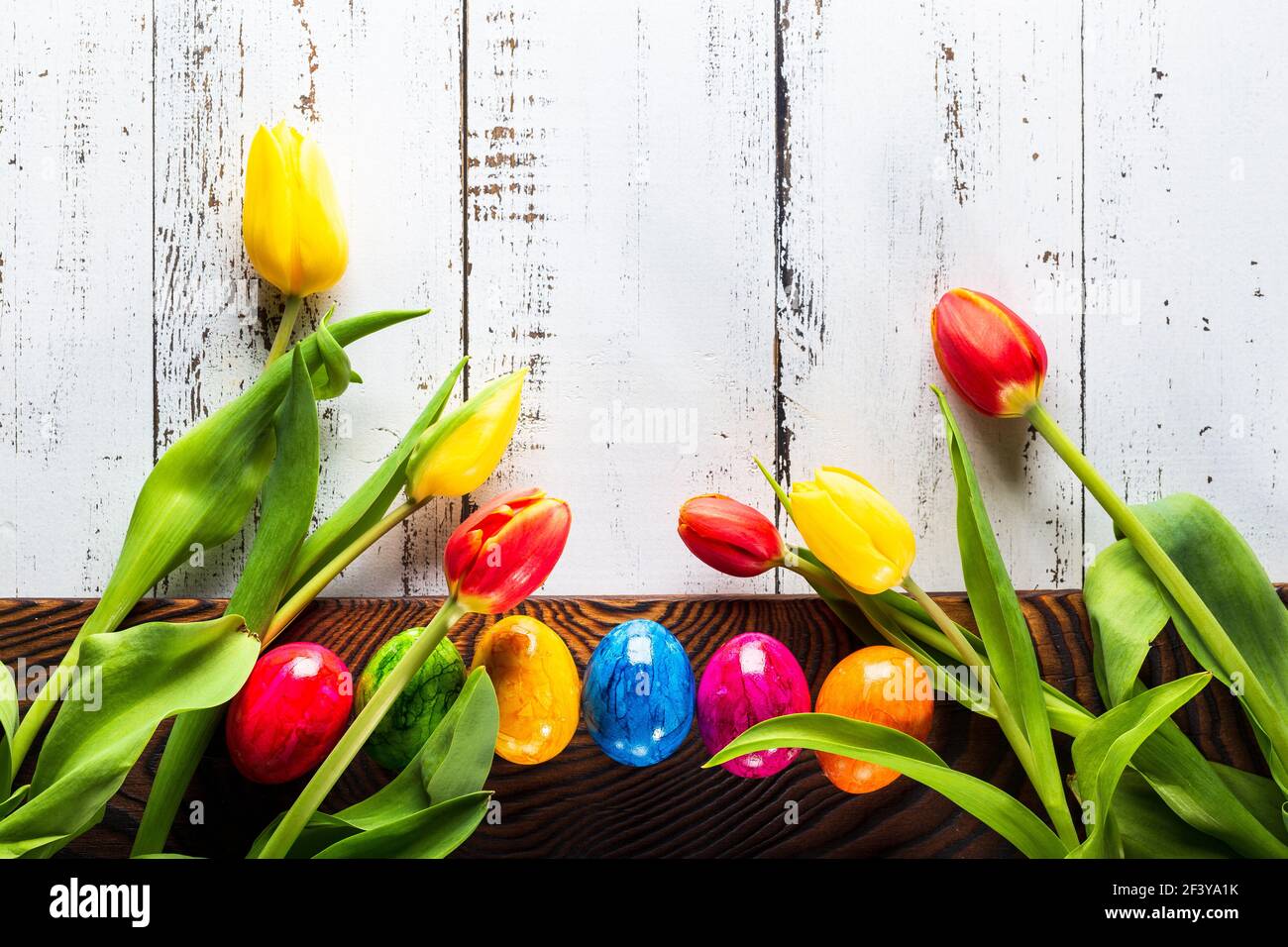 Fond en bois de Pâques avec œufs de couleur. Banque D'Images