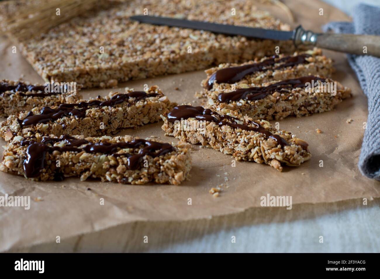 Vue rapprochée d'une barre de muesli fraîche et maison sans cuisson avec noix, sésame, sucettes d'amaranth et avoine soufflée. Fait avec du miel et du sirop d'érable Banque D'Images