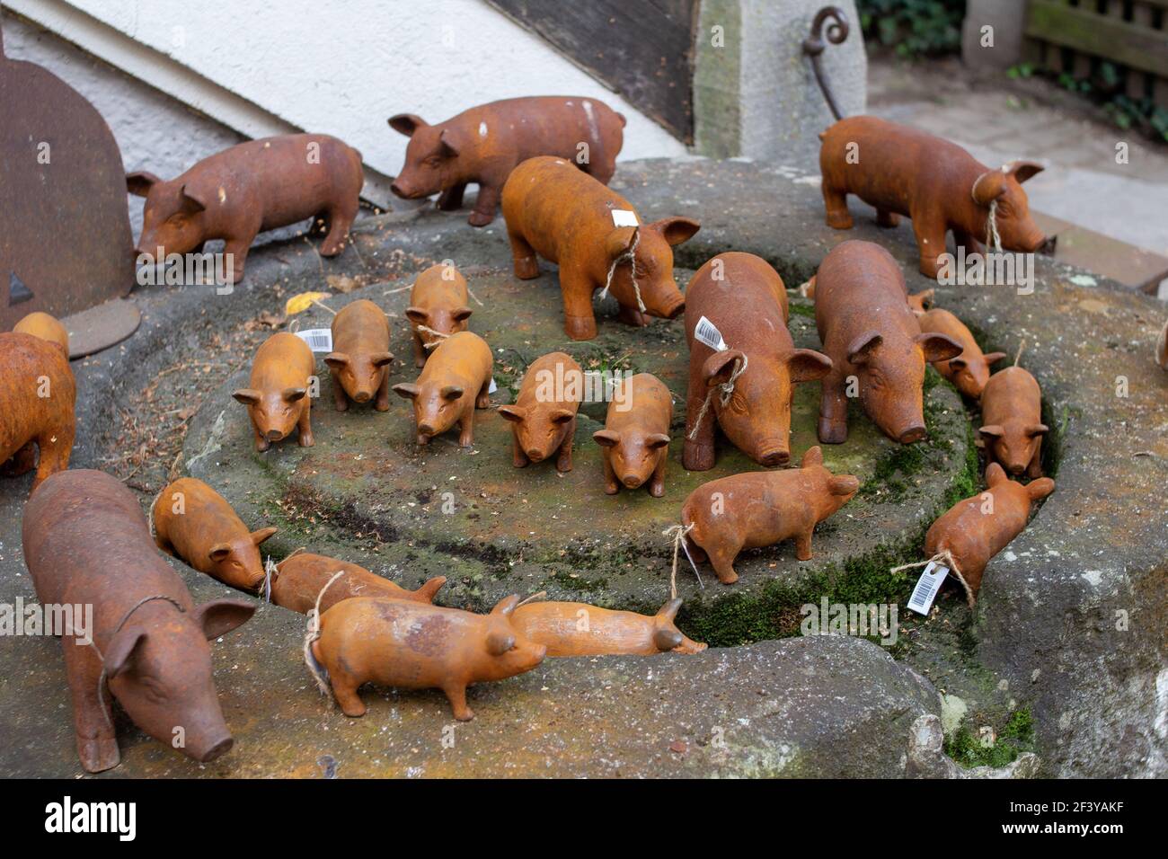 Un gros plan de petites sculptures de cochon sur une pierre surface extérieure Banque D'Images