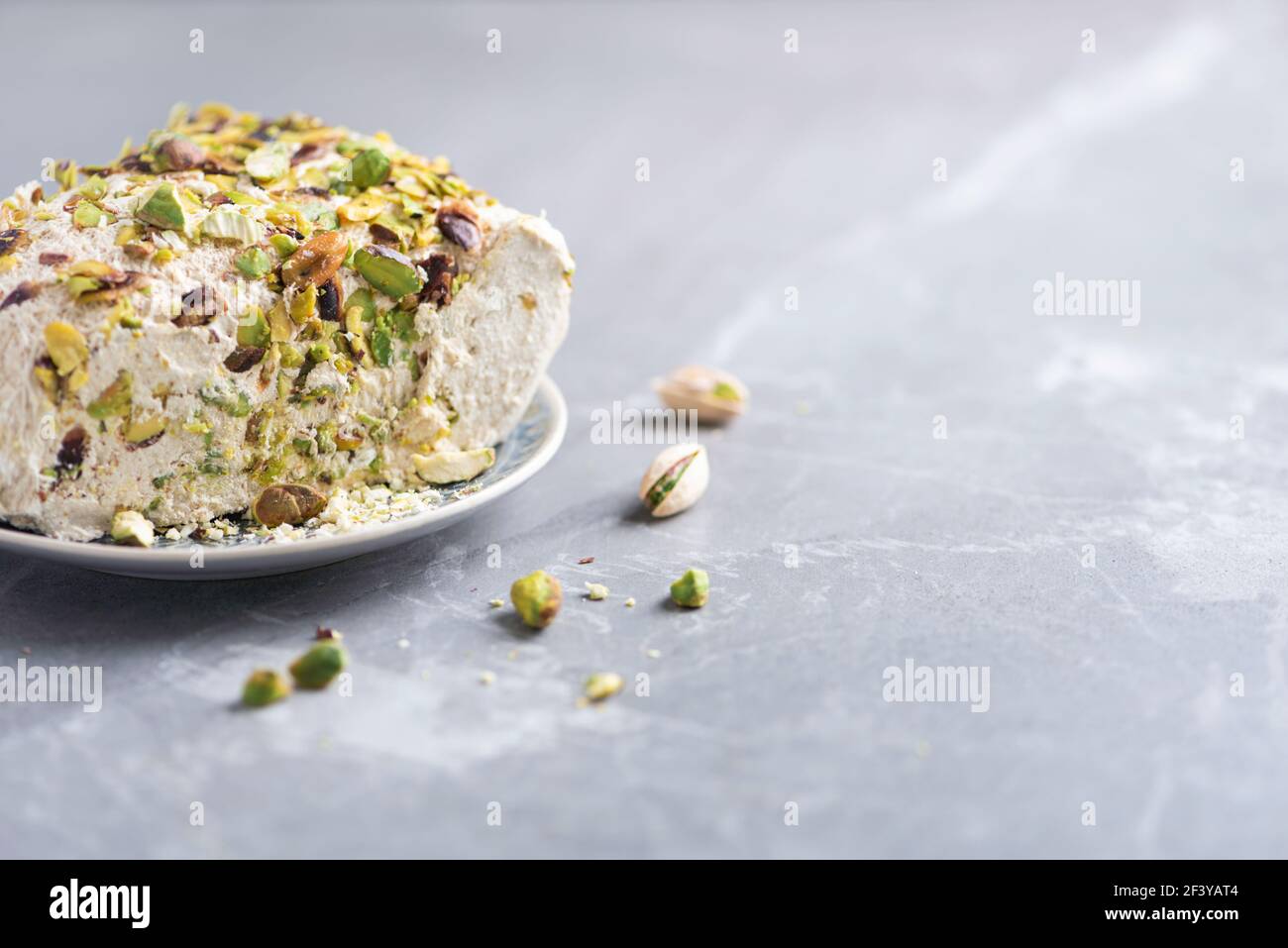 Halva de sésame avec pistaches sur fond gris. Vue de dessus. Copier l'espace. Bonbons traditionnels du Moyen-Orient. Dessert national juif, turc, arabe Banque D'Images