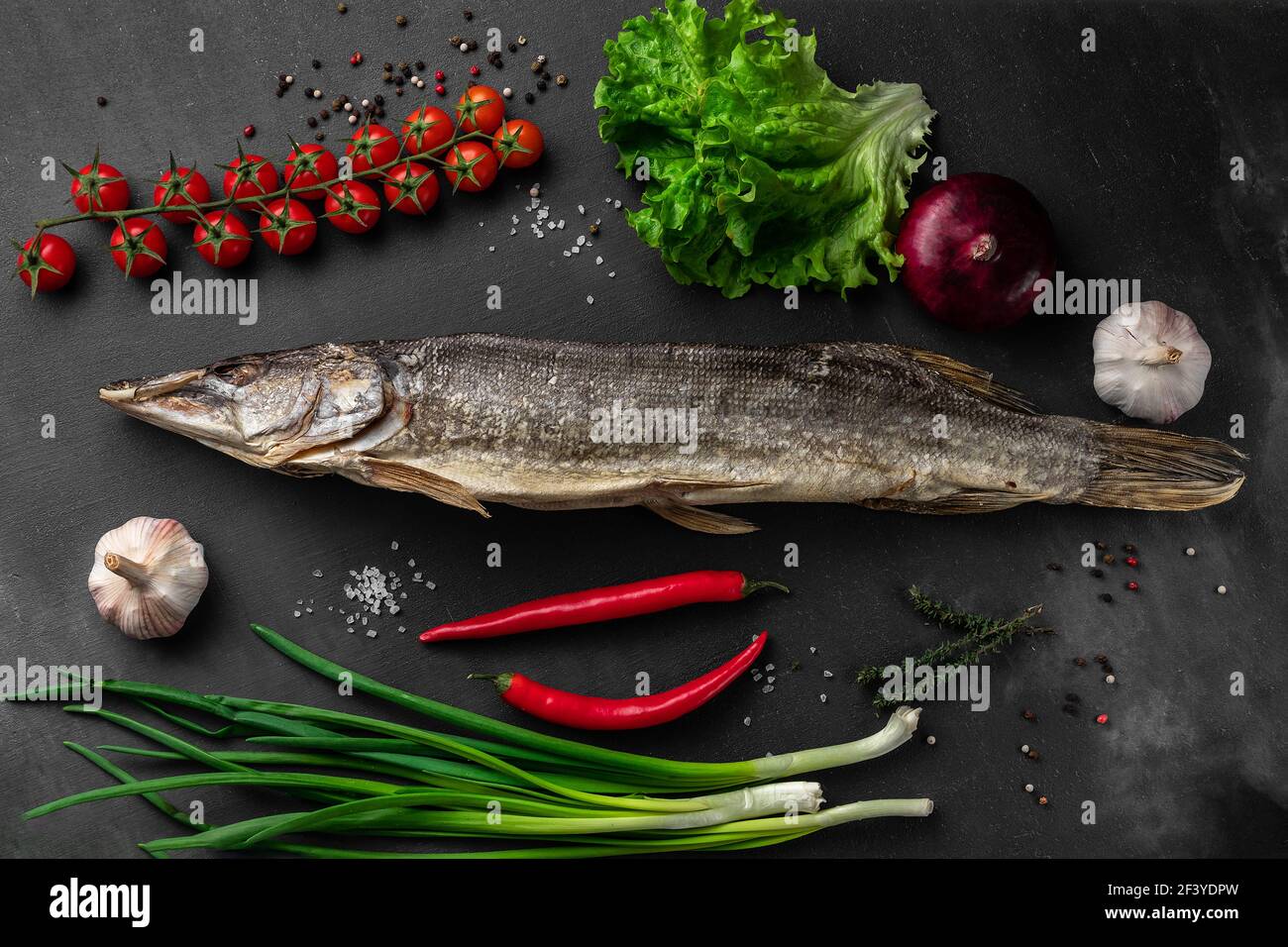 poisson de brochet séché avec des légumes sur fond noir vue de dessus, concept de marché agricole Banque D'Images