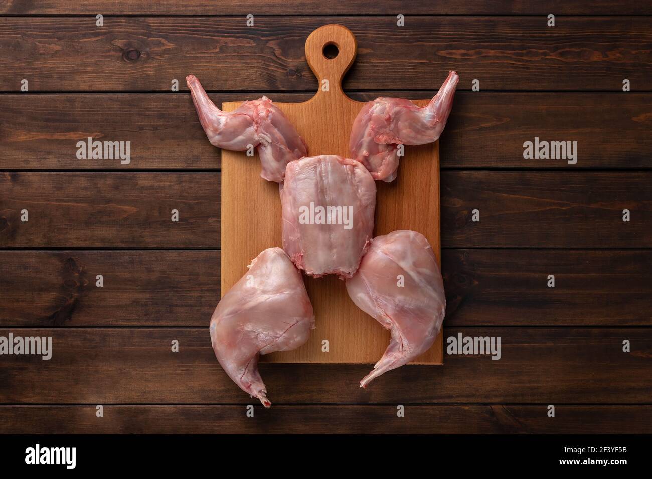 viande de lapin entier rouge frais sur une planche à découper en bois, espace de copie Banque D'Images