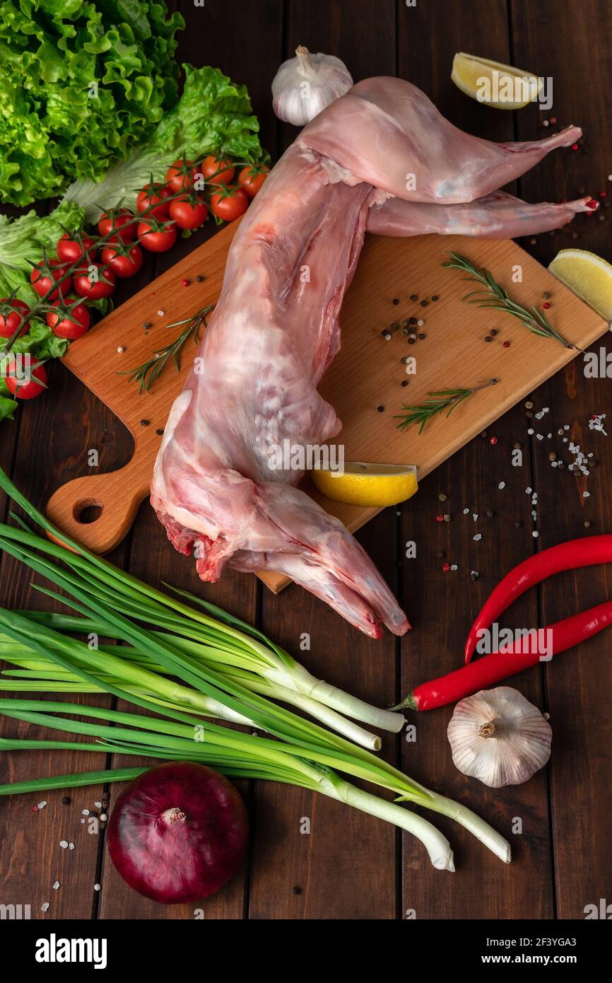 viande de lapin rouge fraîche sur une planche à découper en bois, vue latérale Banque D'Images