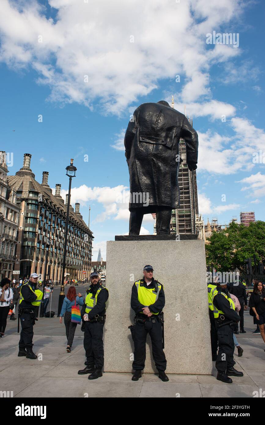 Les officiers de police métropolitaine entourant la statue de Sir Winston Churchill, place du Parlement, à la suite des manifestants du BLM qui ont endommagé des statues. Banque D'Images