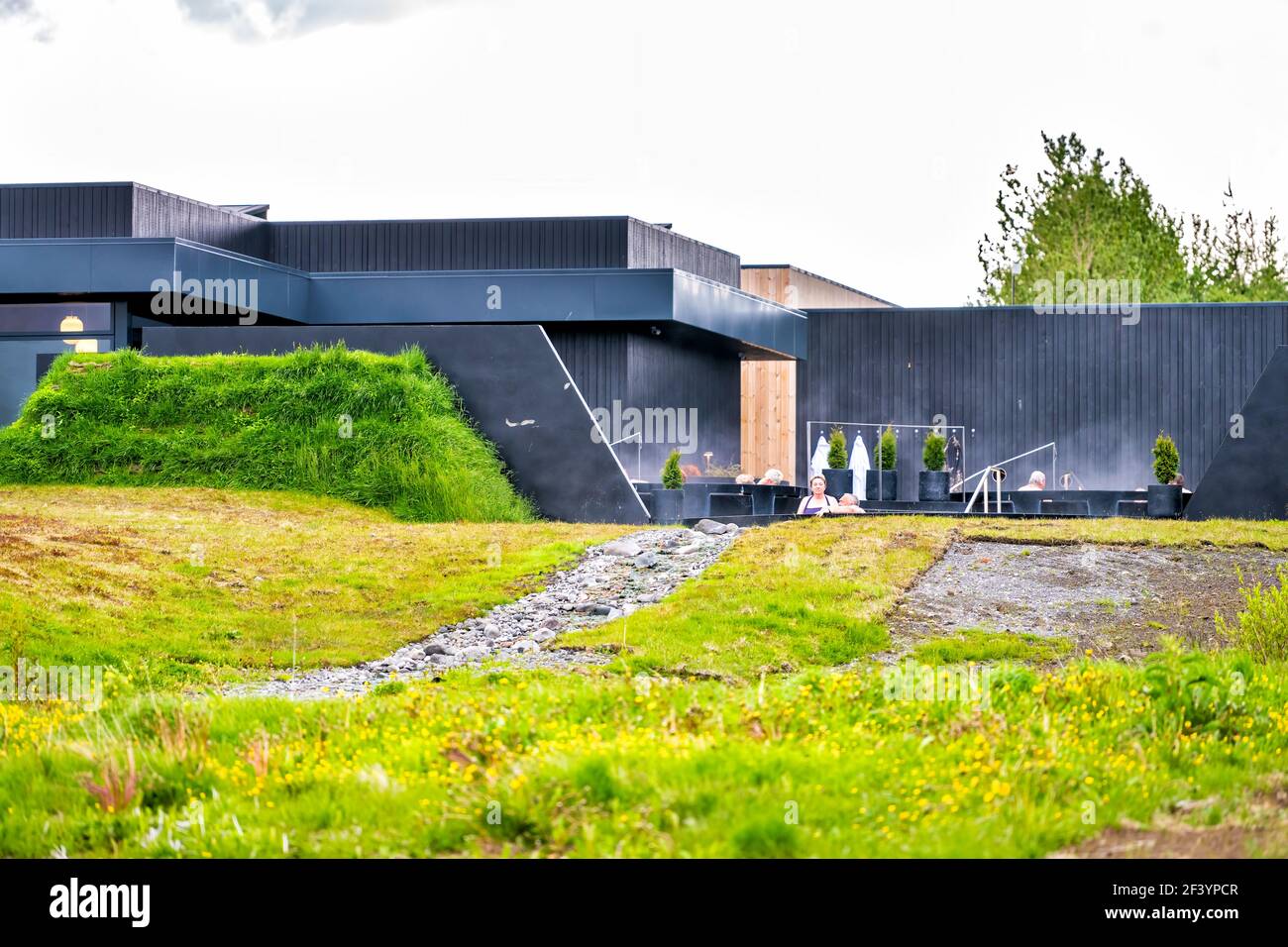 Deildartunguhver, Islande - 18 juin 2018: Krauma Hot Springs Resort spa voyage bâtiment architecture moderne et personnes nageant dans l'eau chaude à l'extérieur Banque D'Images