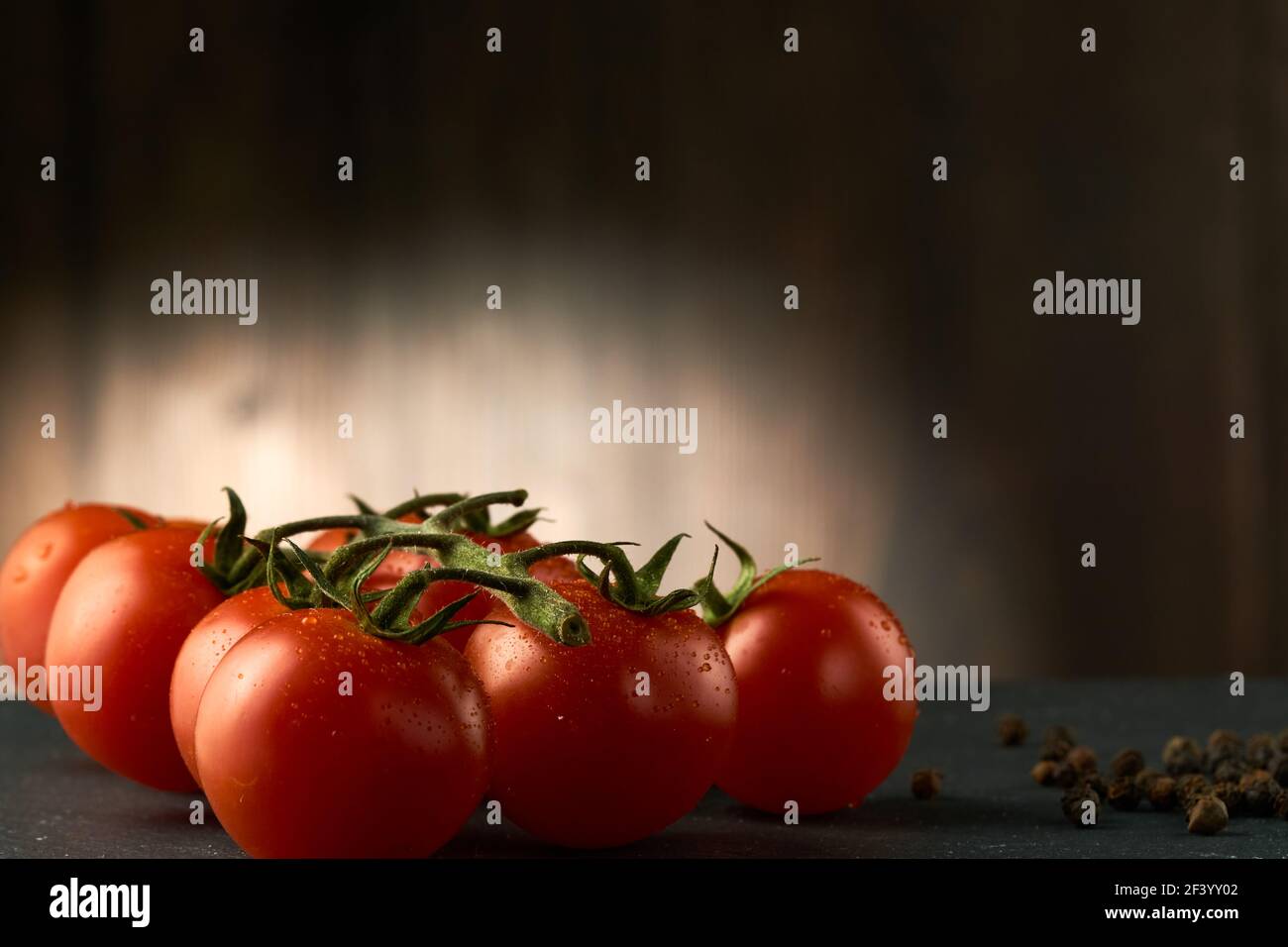 Tomates cerises sur une table en pierre noire. L'image peut également être utilisée comme texture, j'ai laissé un espace pour le texte sur le côté droit. Banque D'Images