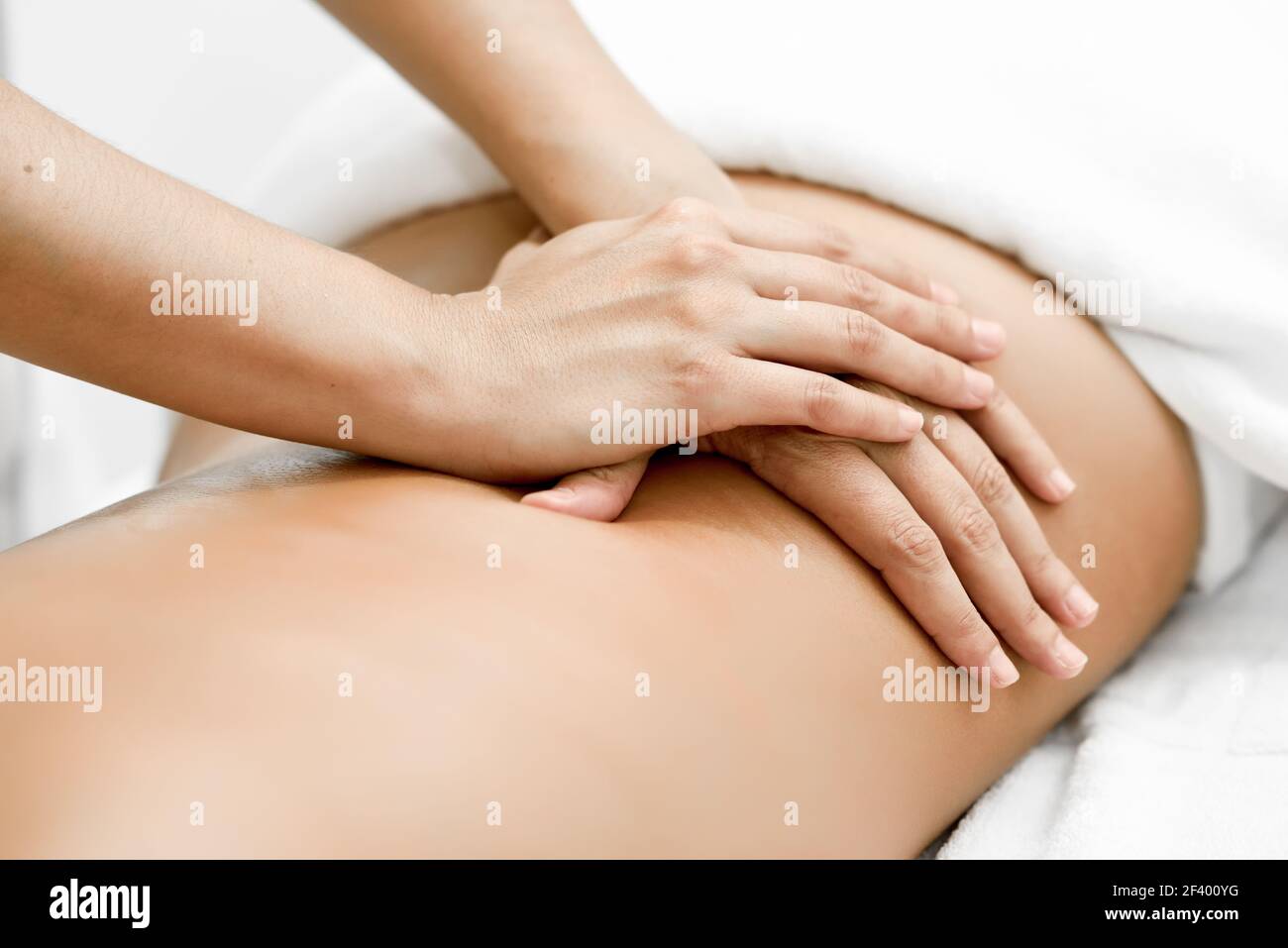 Jeune femme recevant un massage arrière dans un centre de spa. Patiente est sous traitement par un thérapeute professionnel. Banque D'Images