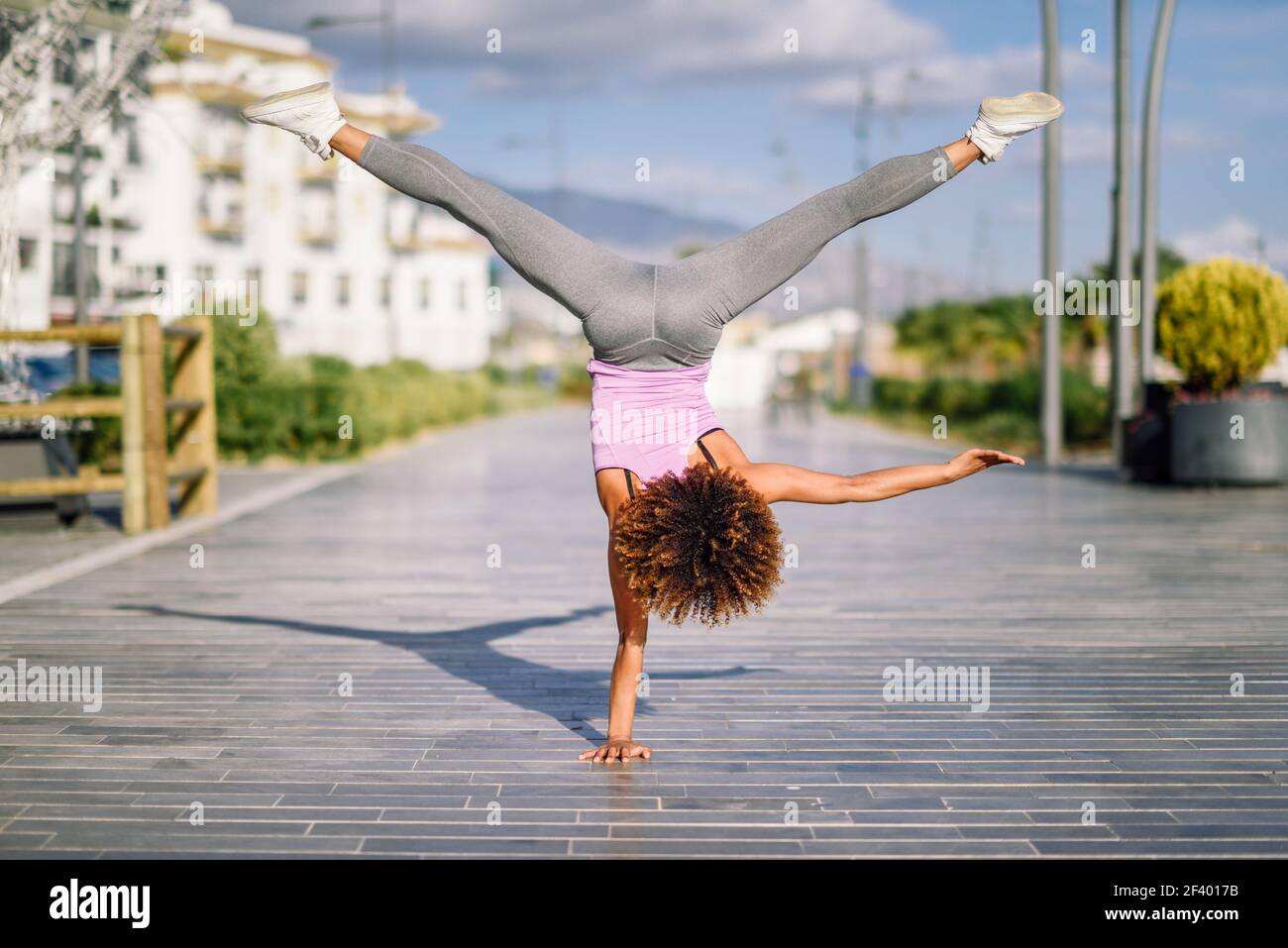 Femme de forme noire faisant des acrobaties de forme physique en milieu urbain. Femme de forme noire faisant des acrobaties de forme physique en milieu urbain. Jeunes femmes qui font de l'exercice et font de l'exercice dur. Banque D'Images