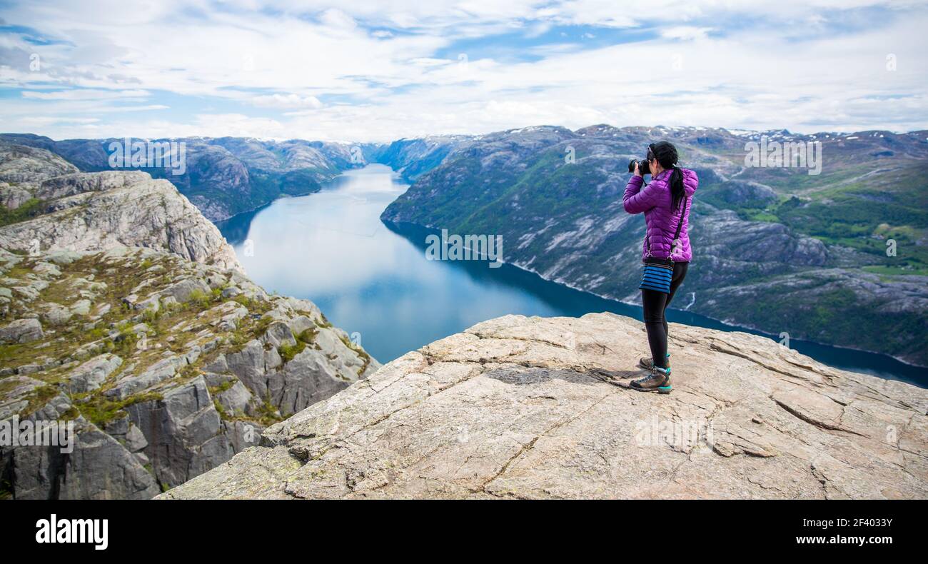 Photographe nature belle nature Norvège Preikestolen ou Prek. Photographe de la nature touriste avec des prises de vue en se tenant au sommet de la montagne. Belle nature Norvège Preikestolen ou Prekestolen. Banque D'Images