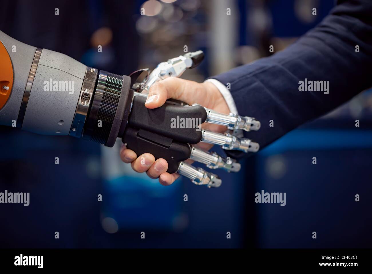 Main d'un homme d'affaires qui se secoue avec un robot Android. Main d'un homme d'affaires qui se secoue avec un robot Android. Le concept de l'interaction humaine avec l'intelligence artificielle. Banque D'Images