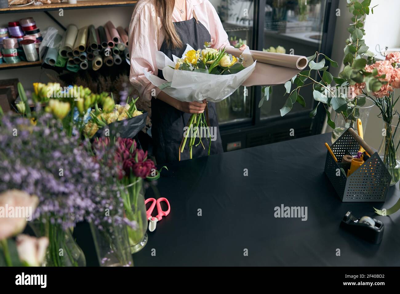 Photo d'un fleuriste tenant de belles fleurs dans un magasin de fleurs, espace de copie. Boutique de fleurs Lifestyle. Belle composition florale Banque D'Images