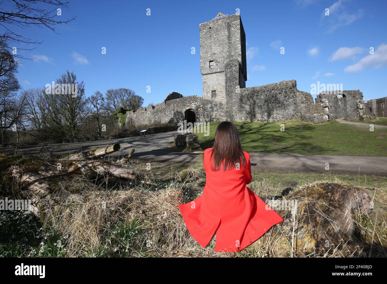Mugdock Country Park (Milngavie) East Dunbartonshire, Écosse, Royaume-Uni, 17 mars 2021. Femme en manteau rouge avec dos à l'appareil photo Banque D'Images