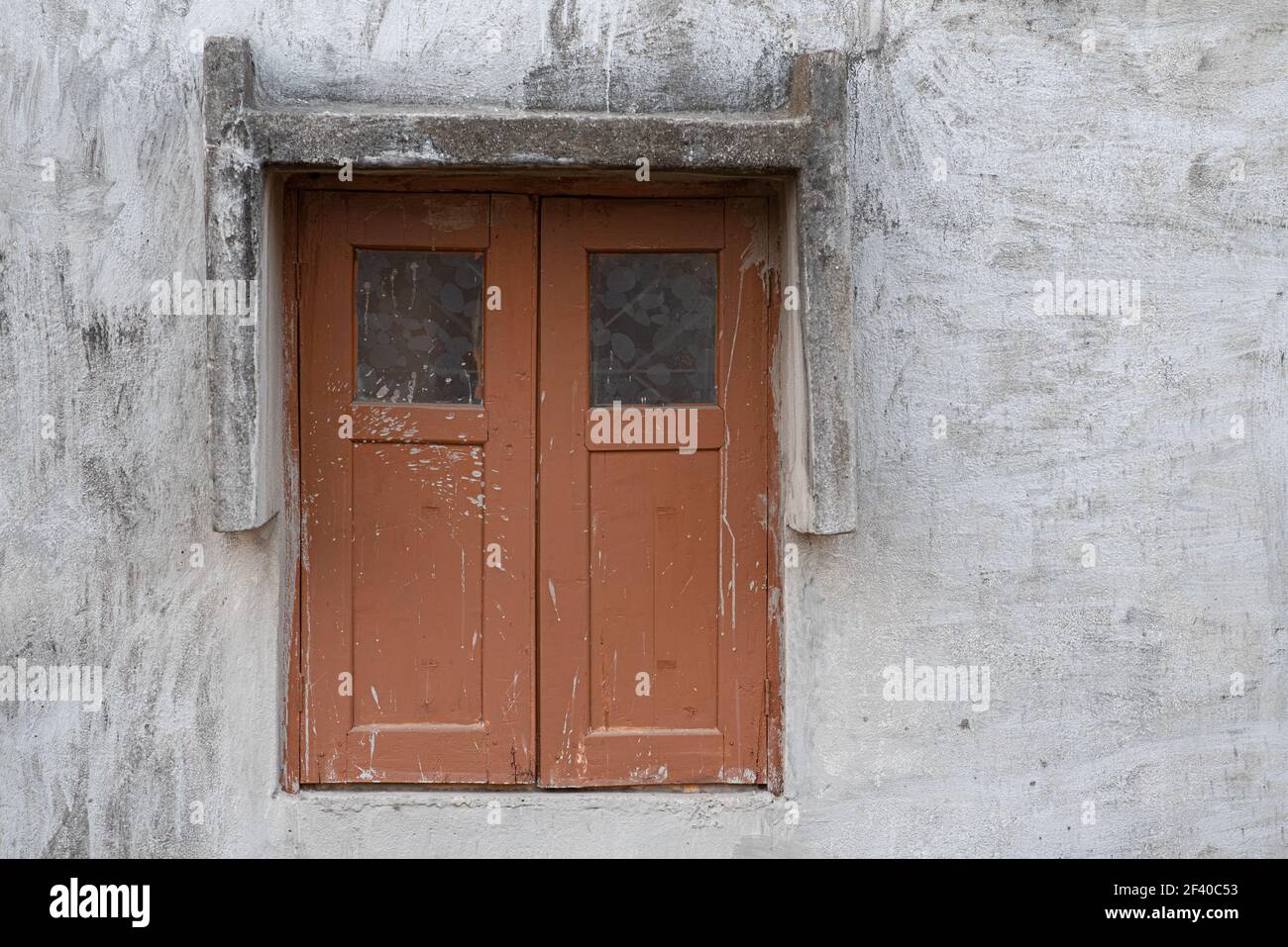 Une belle photo d'une vieille fenêtre en bois avec des taches et des fissures sur un mur de ciment Banque D'Images