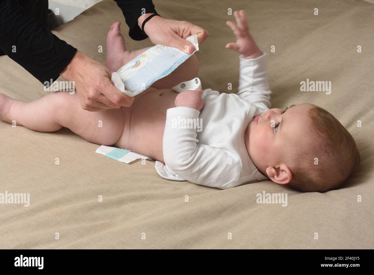 changer la couche sur le bébé qui est couché lit Photo Stock Alamy