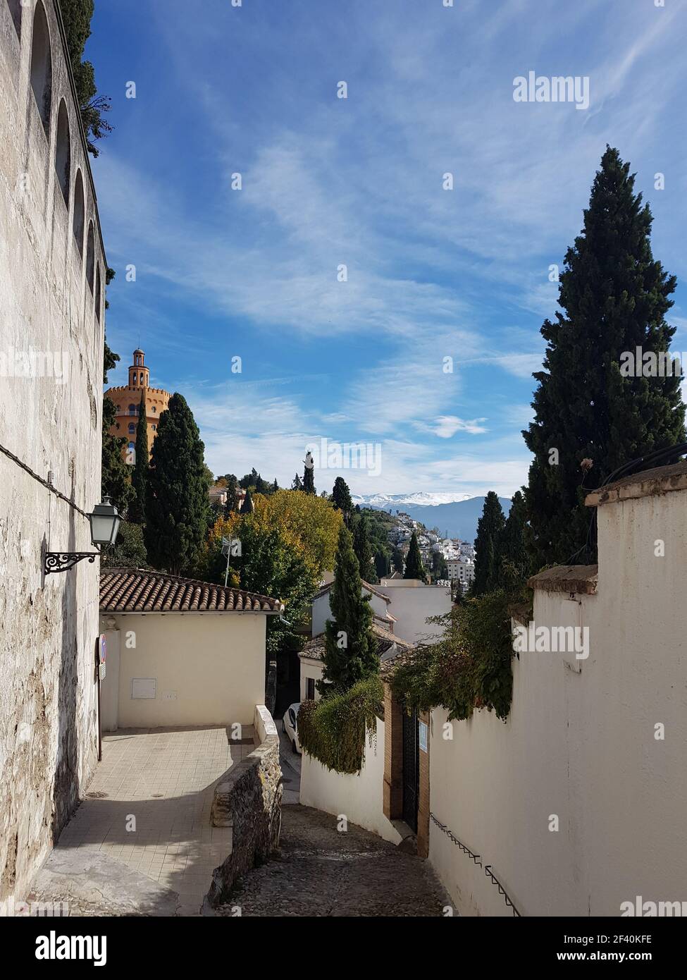 Vue sur la rue Grenade dans le quartier de Realejo avec vue sur la Sierra Nevada et le palais de l'Alhambra. Andalousie, Espagne. Granada Street dans le quartier de Realejo avec vue sur la Sierra Nevada Banque D'Images