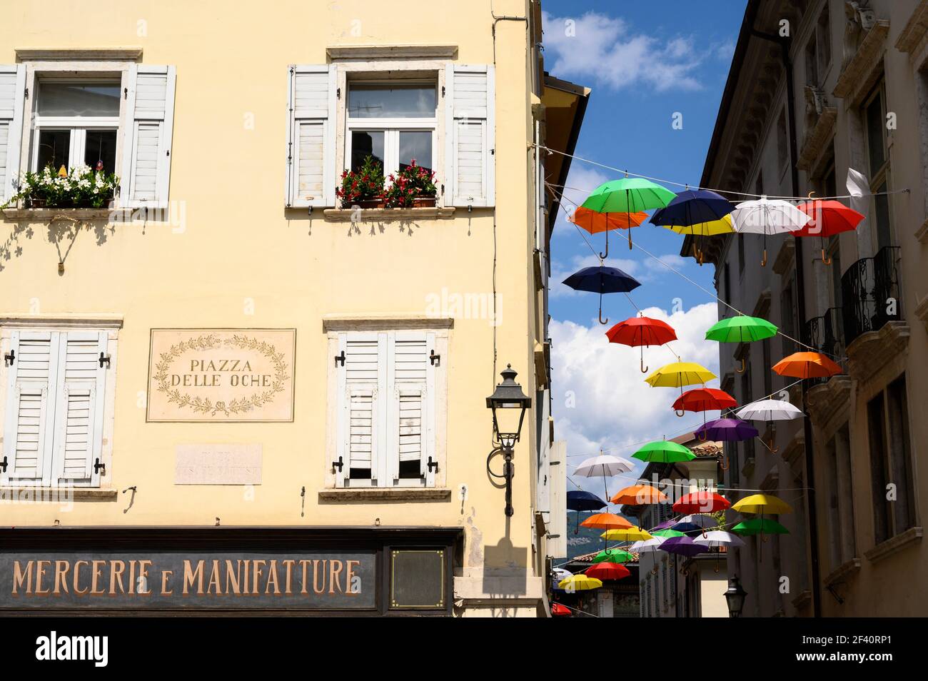 Rovereto. Italie. Parasols colorés sur la Piazza Cesare Battisti (Piazza delle Oche) dans le centre historique de la ville. Banque D'Images