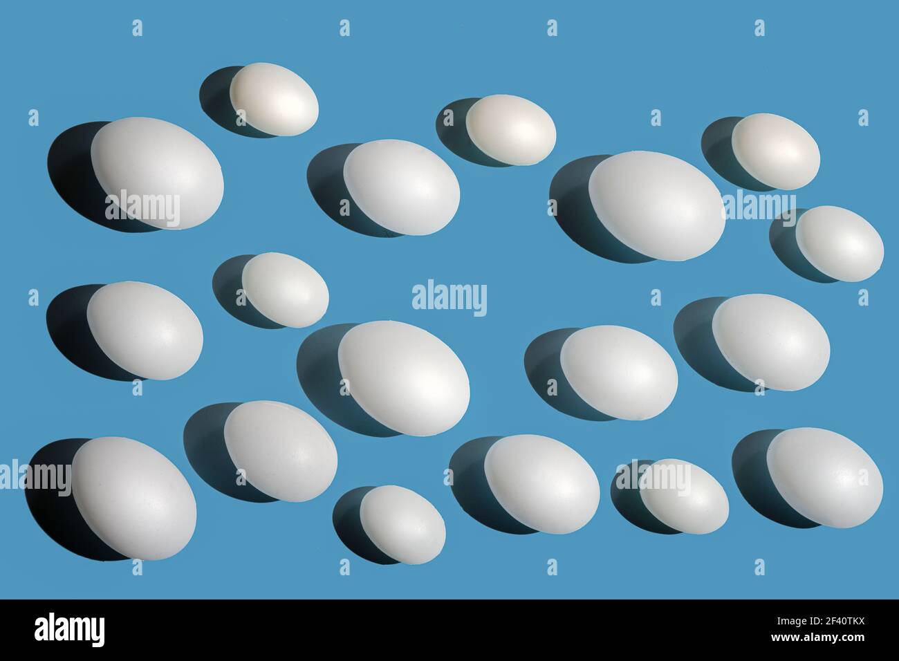 Quelques œufs blancs sur une surface bleue Banque D'Images