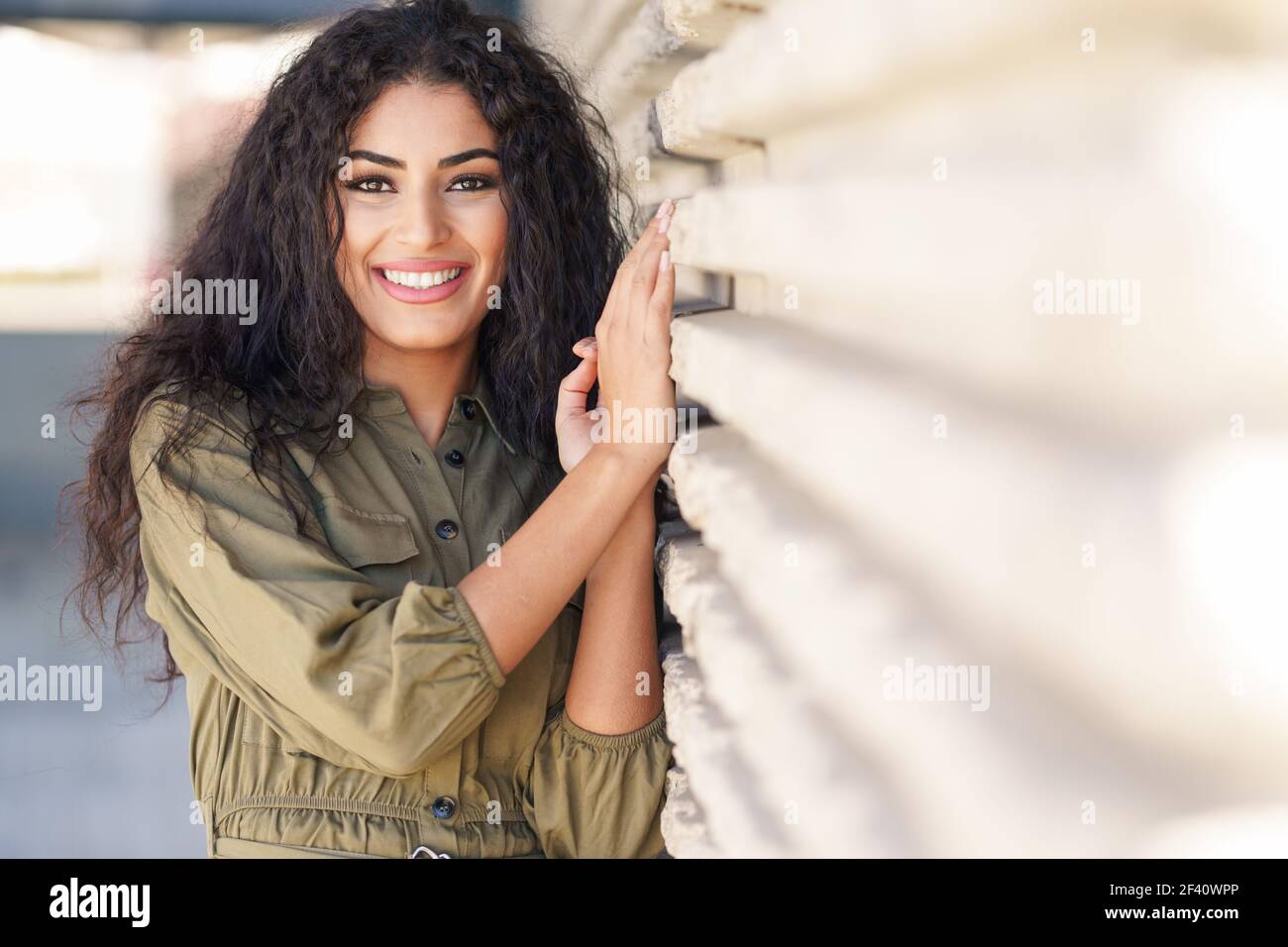 Jeune femme arabe aux cheveux bouclés souriant à l'extérieur. Jeune femme arabe avec des cheveux bouclés à l'extérieur Banque D'Images