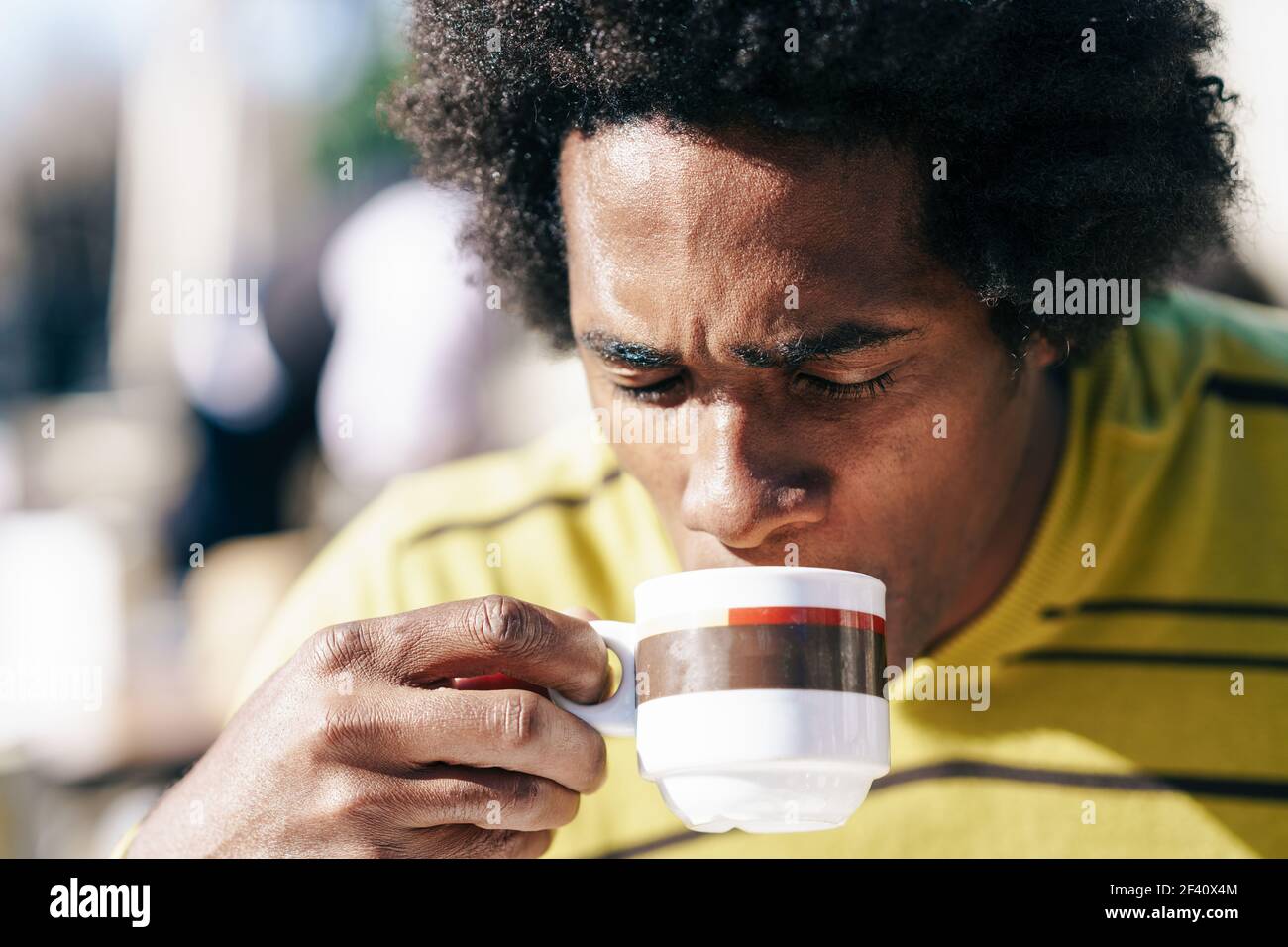 L'homme noir cubain appréciant un café tout en étant assis à la table à l'extérieur lors de son voyage à Grenade, Espagne. Homme noir appréciant le café dans le café tout en étant assis à la table à l'extérieur Banque D'Images