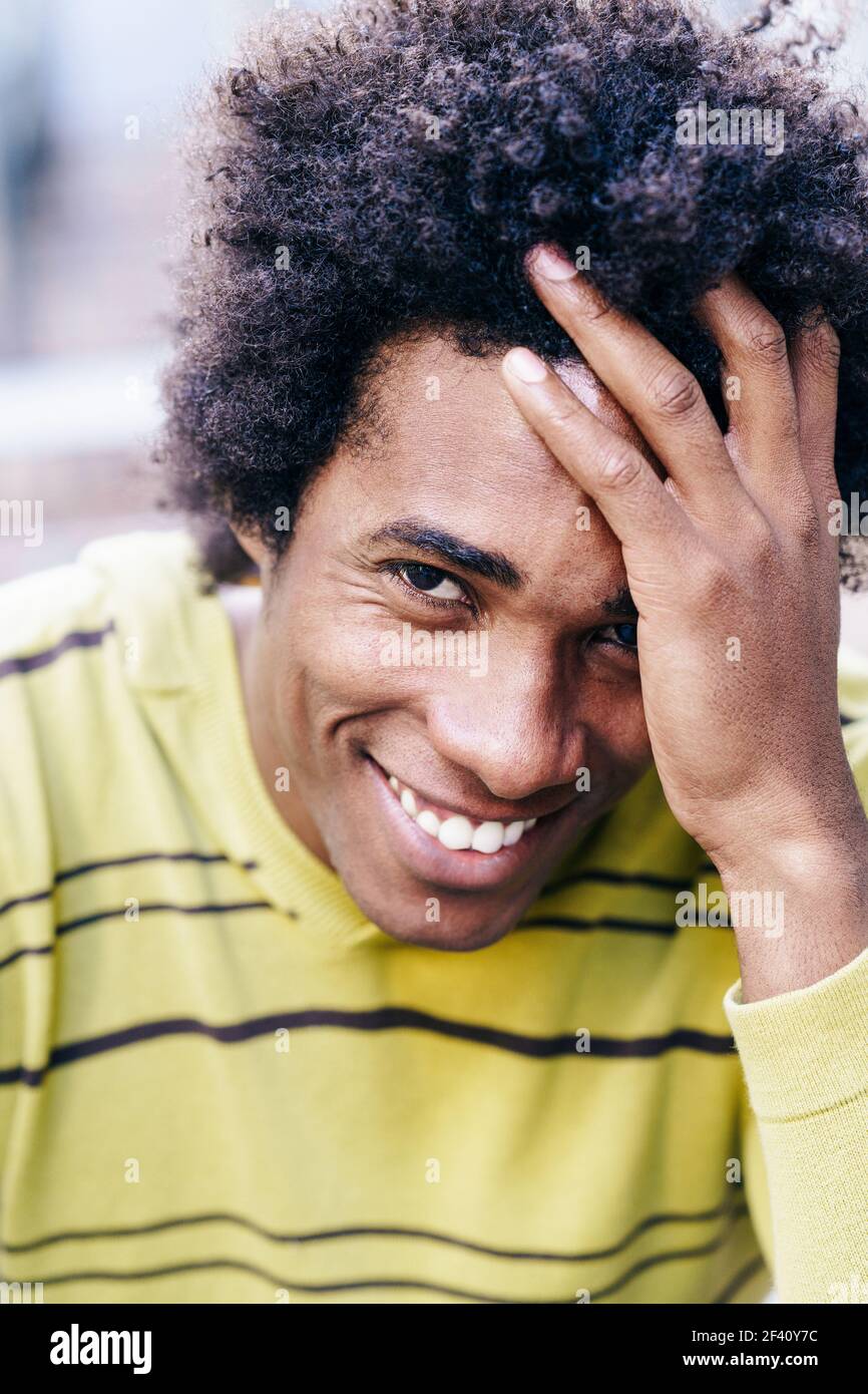 Touriste noir cubain avec des cheveux afro assis sur le sol souriant à l'appareil photo. Touriste noir cubain avec cheveux afro assis sur le sol Banque D'Images