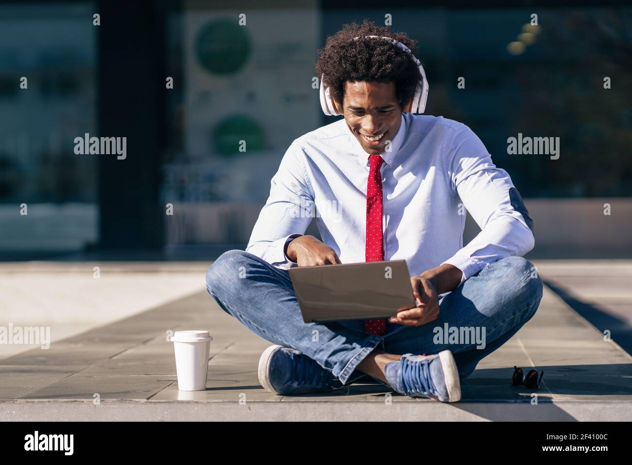 Homme d'affaires noir ayant une vidéoconférence avec ordinateur portable et casque Homme avec cheveux afro.. Homme d'affaires noir utilisant un ordinateur portable et un casque Banque D'Images