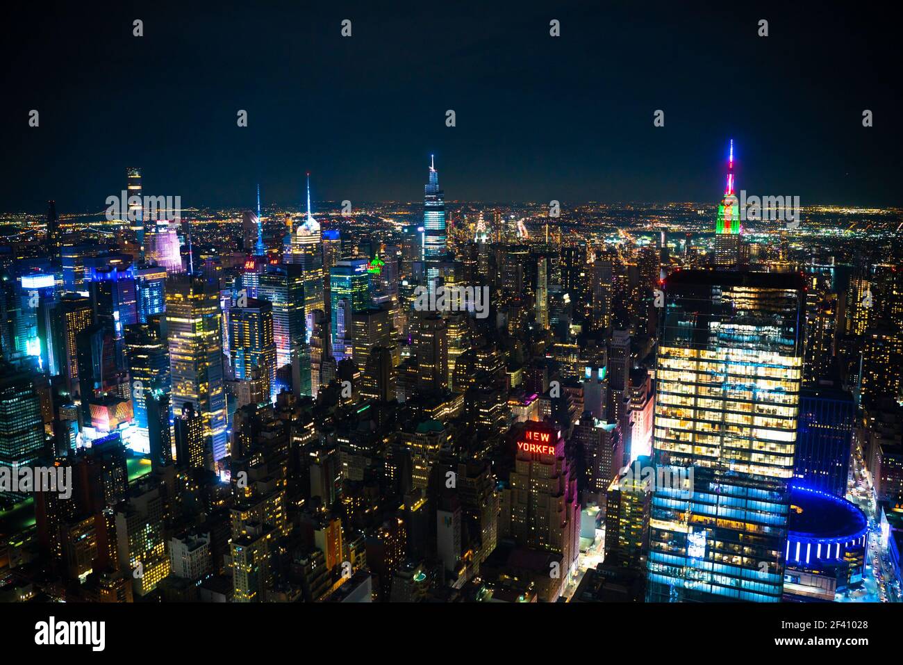 Scène nocturne à travers la ville de Manhattan, New York avec de nombreux bâtiments illuminés par une nuit sombre Banque D'Images