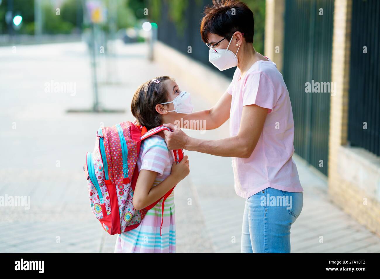 La mère prépare sa petite fille pour le retour à l'école en portant un masque. Concept de retour à l'école. La mère prépare sa petite fille pour le retour à l'école en portant un masque. Banque D'Images