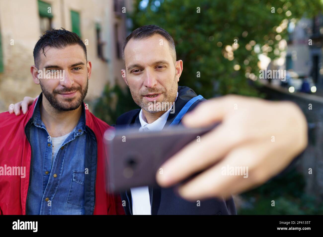 Couple gay faisant un selfie avec leur smartphone. Concept de relation homosexuelle.. Couple gay faisant un selfie avec leur smartphone. Banque D'Images