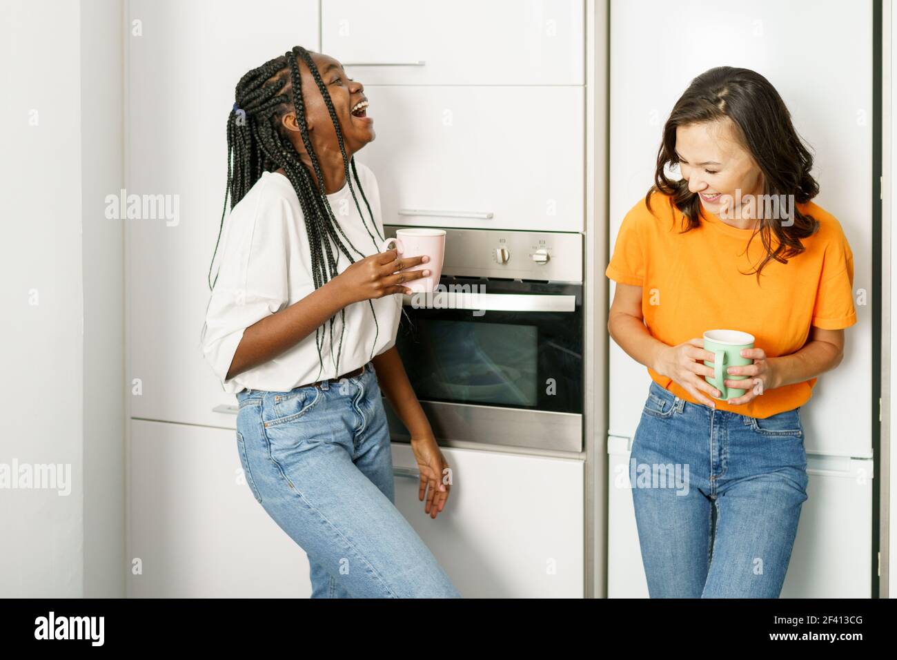 Deux étudiants amis prenant une pause-café ensemble à la maison multiethnique femmes. Deux amis étudiants prenant une pause-café ensemble à la maison. Banque D'Images
