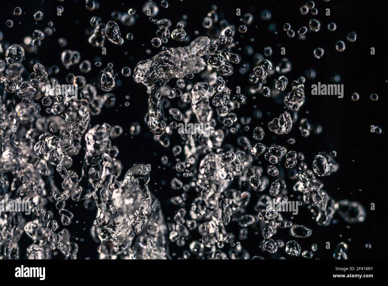 De nombreuses gouttes d'eau congelées dans un air sur fond sombre, concept d'eau. De nombreuses gouttes d'eau congelées dans un air sur fond sombre Banque D'Images