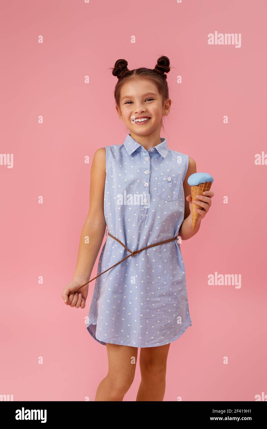 mignonne souriante, petite fille qui mange de la glace Banque D'Images