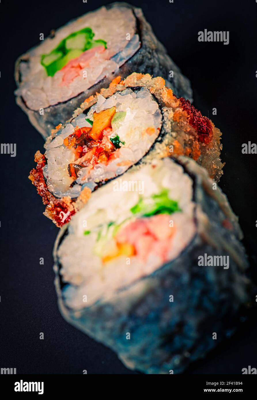 Sushi verticaux alignés sur fond noir. Sushi verticaux alignés sur fond noir Banque D'Images