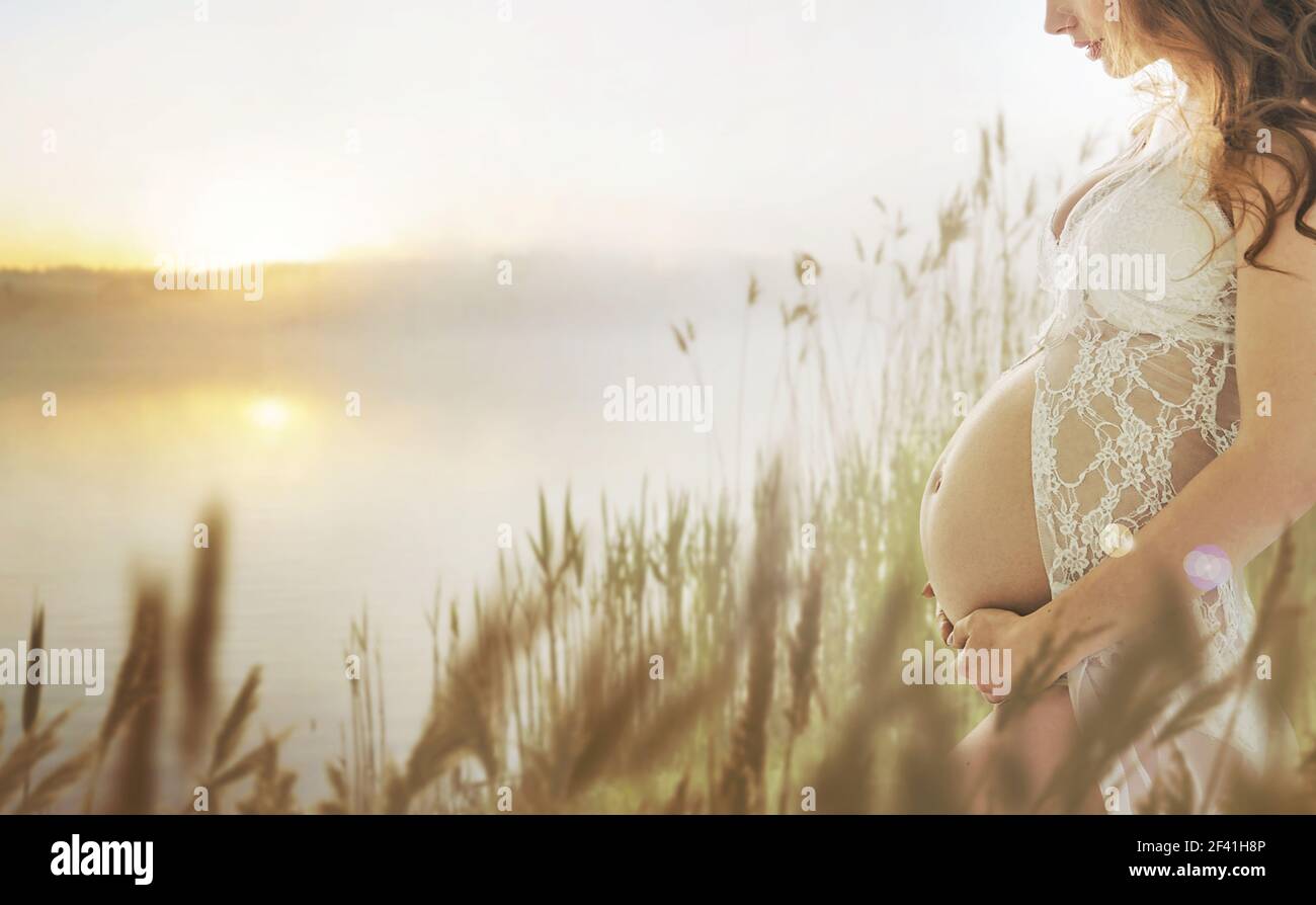 Femme enceinte marche sur la prairie d'été frais Banque D'Images