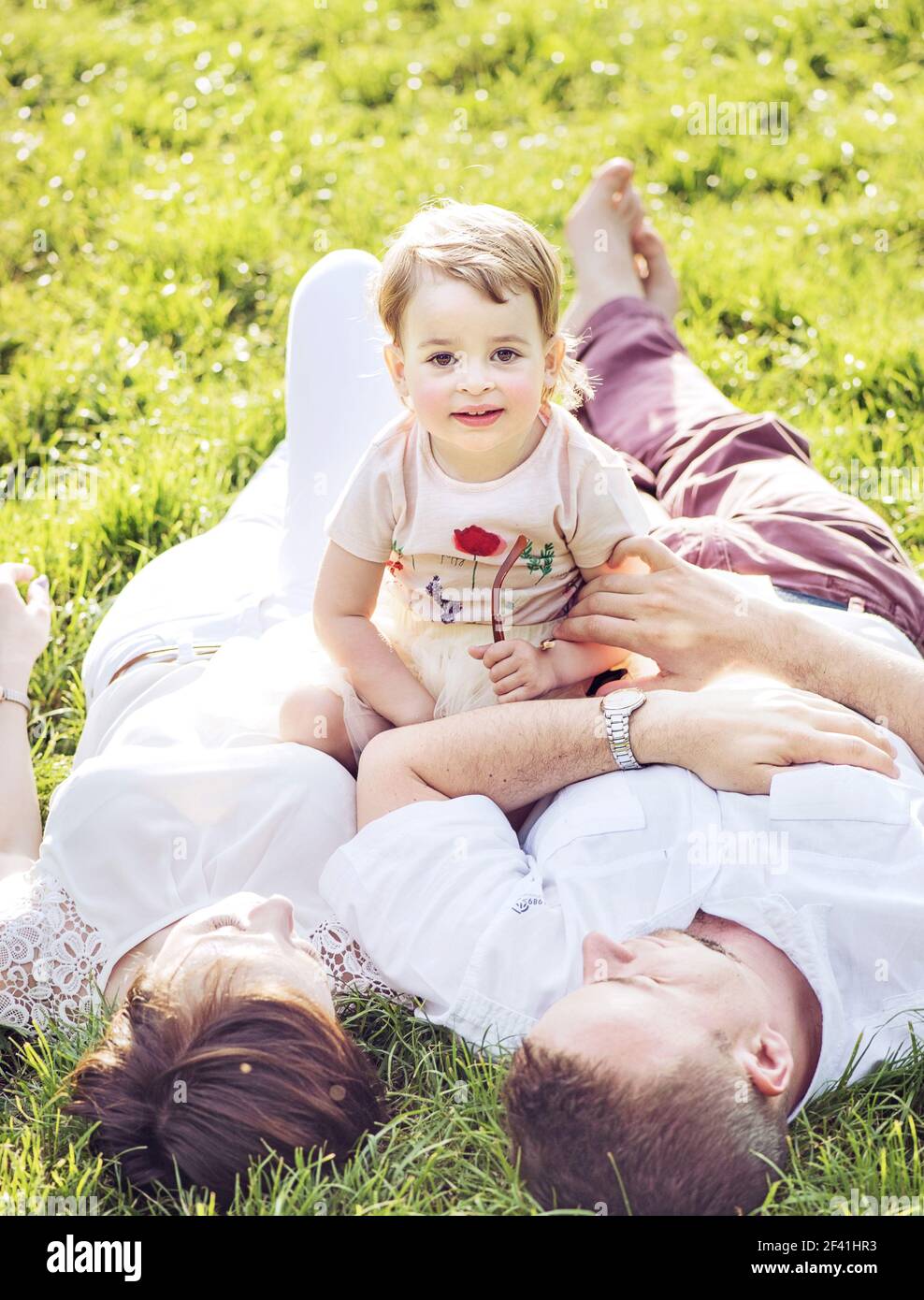 La famille heureux de vous détendre dans un parc d'été Banque D'Images