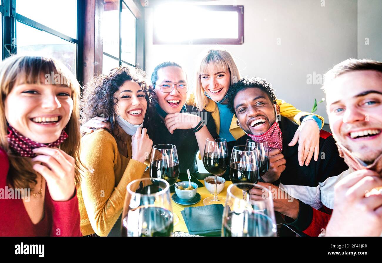 Des amis qui prennent le selfie au bar de la cave de vinification en buvant un verre de vin avec Masque ouvert - les gens s'amusent ensemble au restaurant réouverture Banque D'Images