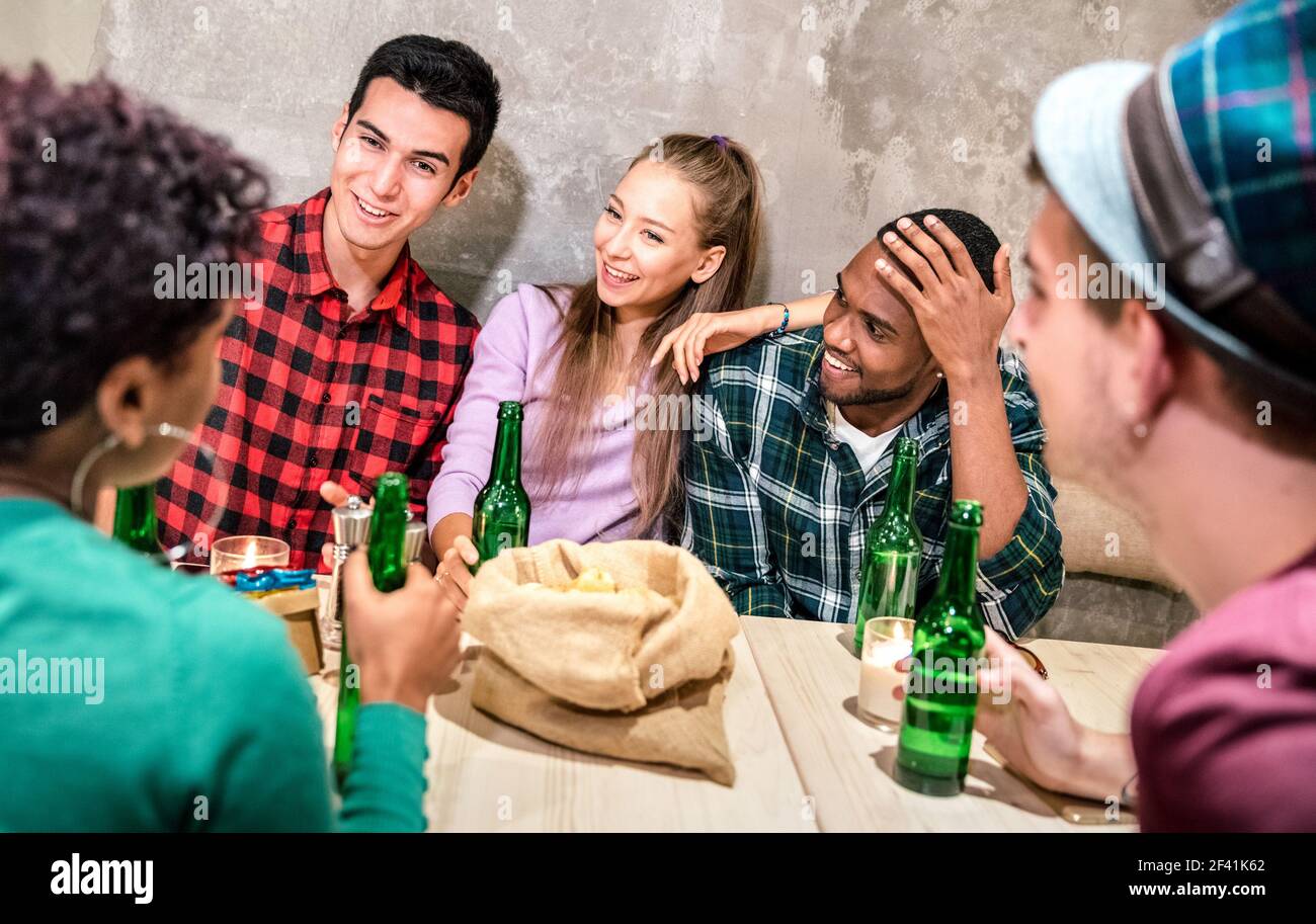 Des amis milléniaux se regroupent pour boire de la bière en bouteille et s'amuser à Bar-restaurant mode - concept d'amitié multiraciale heureux Banque D'Images