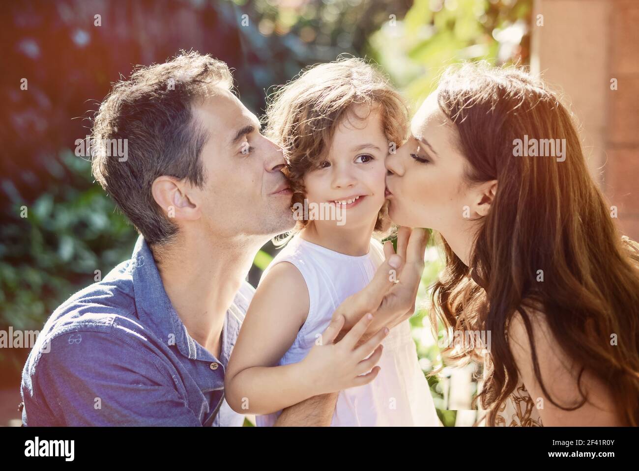 Heureux parents s'embrasser leur fille bien-aimée Banque D'Images