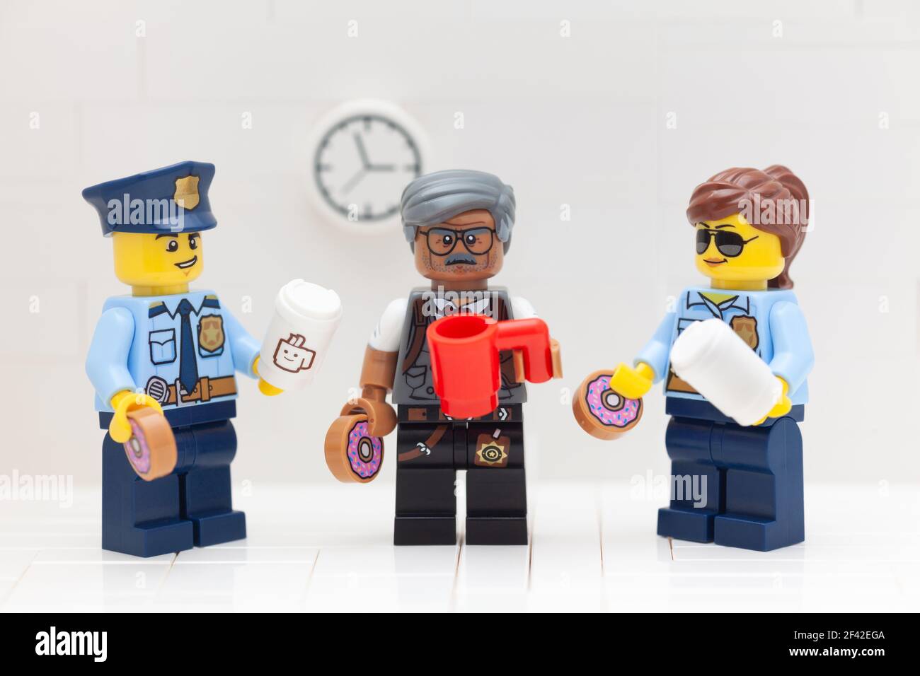 Tambov, Fédération de Russie - 17 mars 2021 Lego policier, policier et commissaire minifigue boire du café et manger des beignets dans leur police Banque D'Images