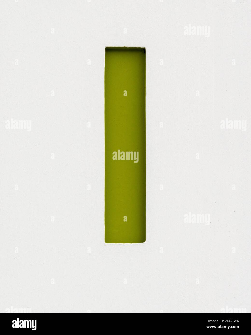 Vert olive lettre I relief inverse sur un mur en béton Banque D'Images