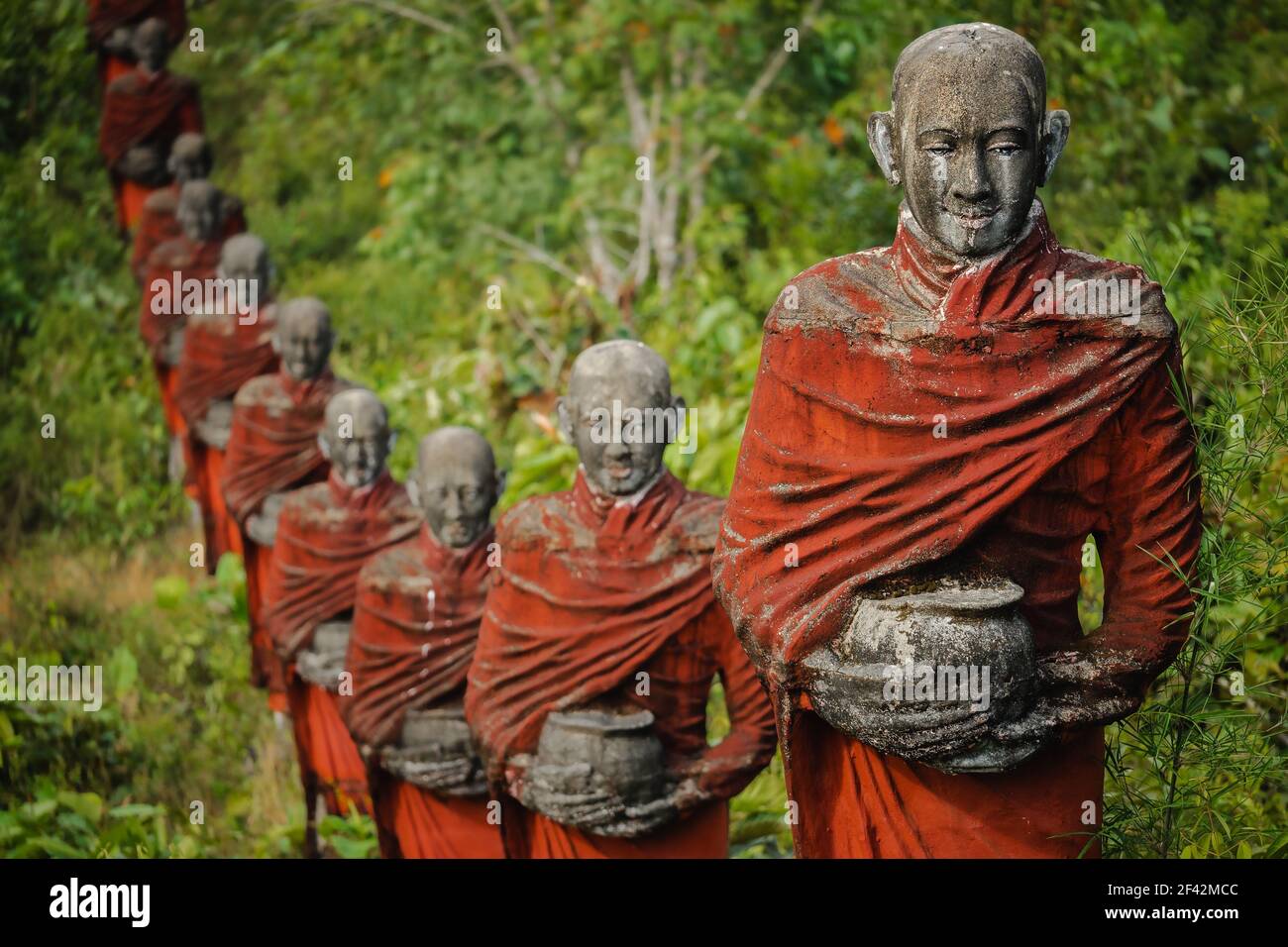 Des centaines de vieilles statues de moines bouddhistes collectant des almes entourent le Bouddha Win Sein Taw ya à Mawlamyine, au Myanmar (Birmanie). Banque D'Images