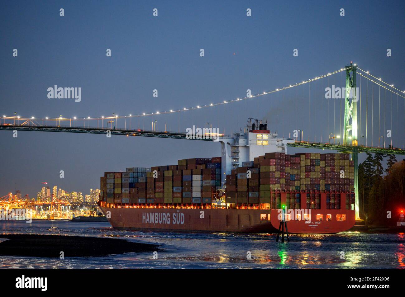 Un bateau à conteneurs entre dans le port de Vancouver et passe sous le pont Lions Gate à Sunset. Maison de pain d'épice de Noël maison. Banque D'Images