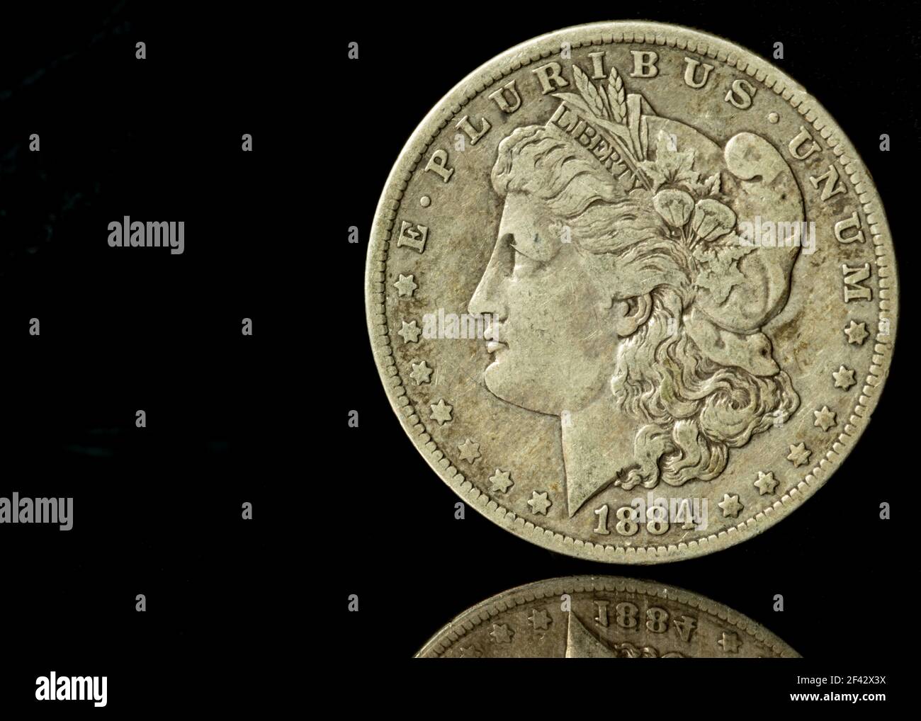 1884 Morgan Silver Dollar contre fond noir avec réflexion Banque D'Images