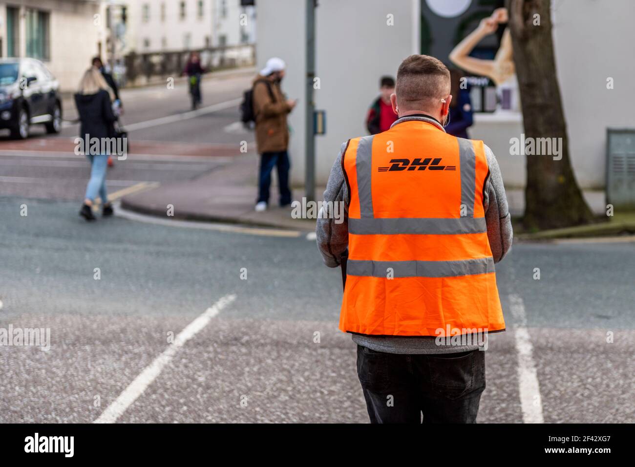 Chauffeur de livraison DHL livrant un colis à Cork, en Irlande. Banque D'Images