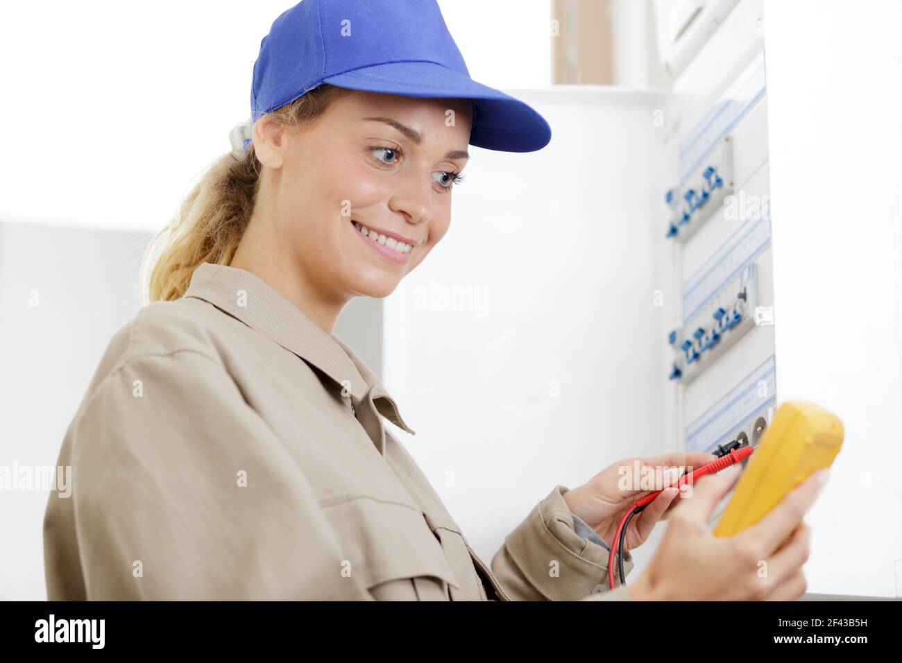 femme technicien qui lit la tension d'un compteur de fuseboad Banque D'Images