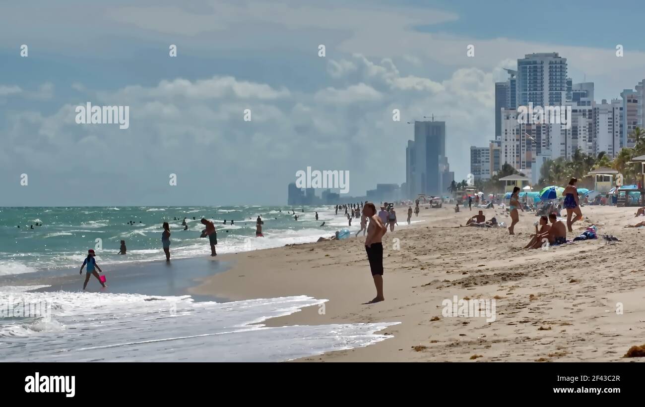 Touristes avec parasols colorés sur Dania Beach, avec des hôtels et des condos en arrière-plan, fort Lauderdale, Floride, États-Unis Banque D'Images